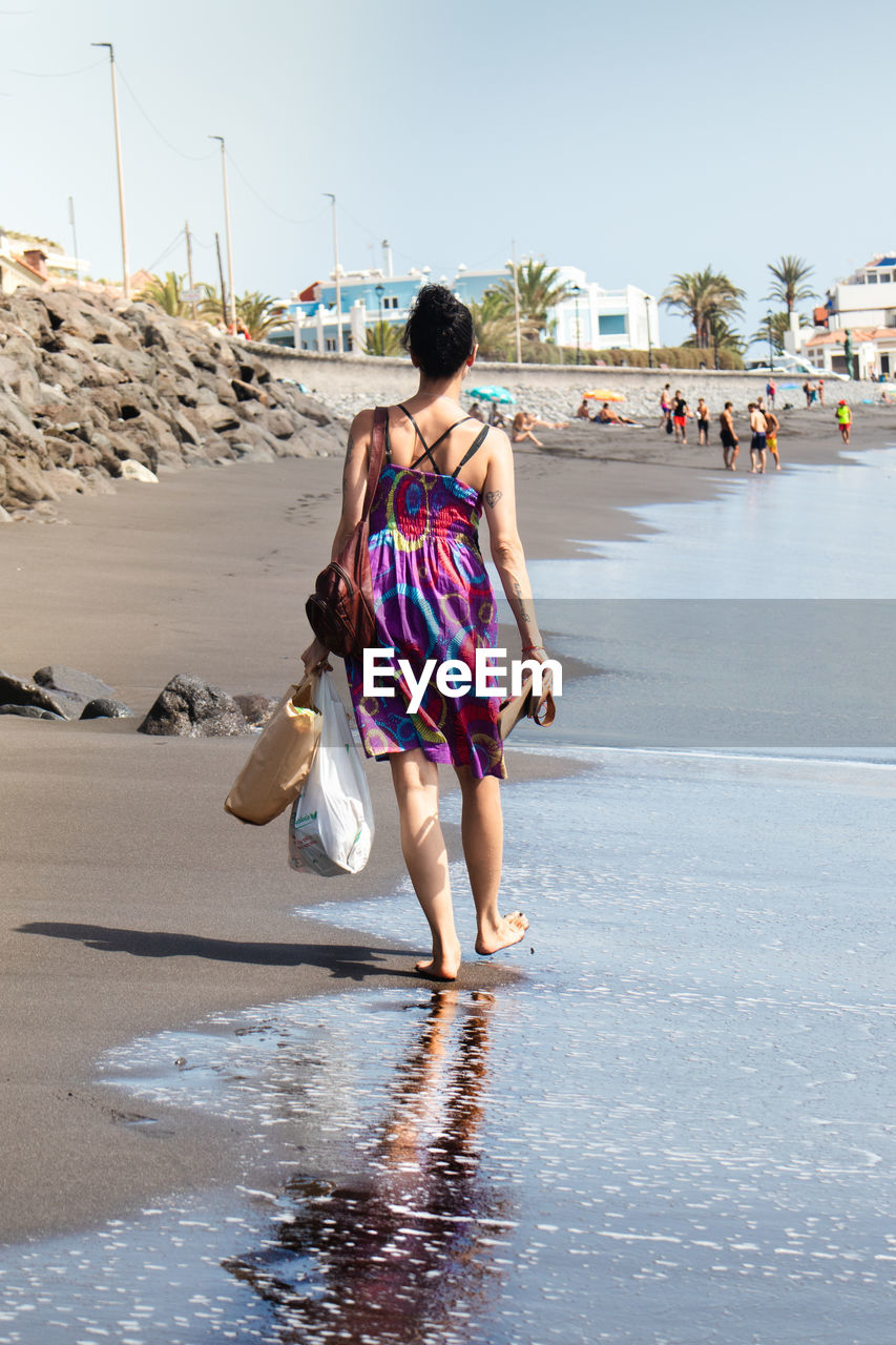 Rear view of woman walking on beach