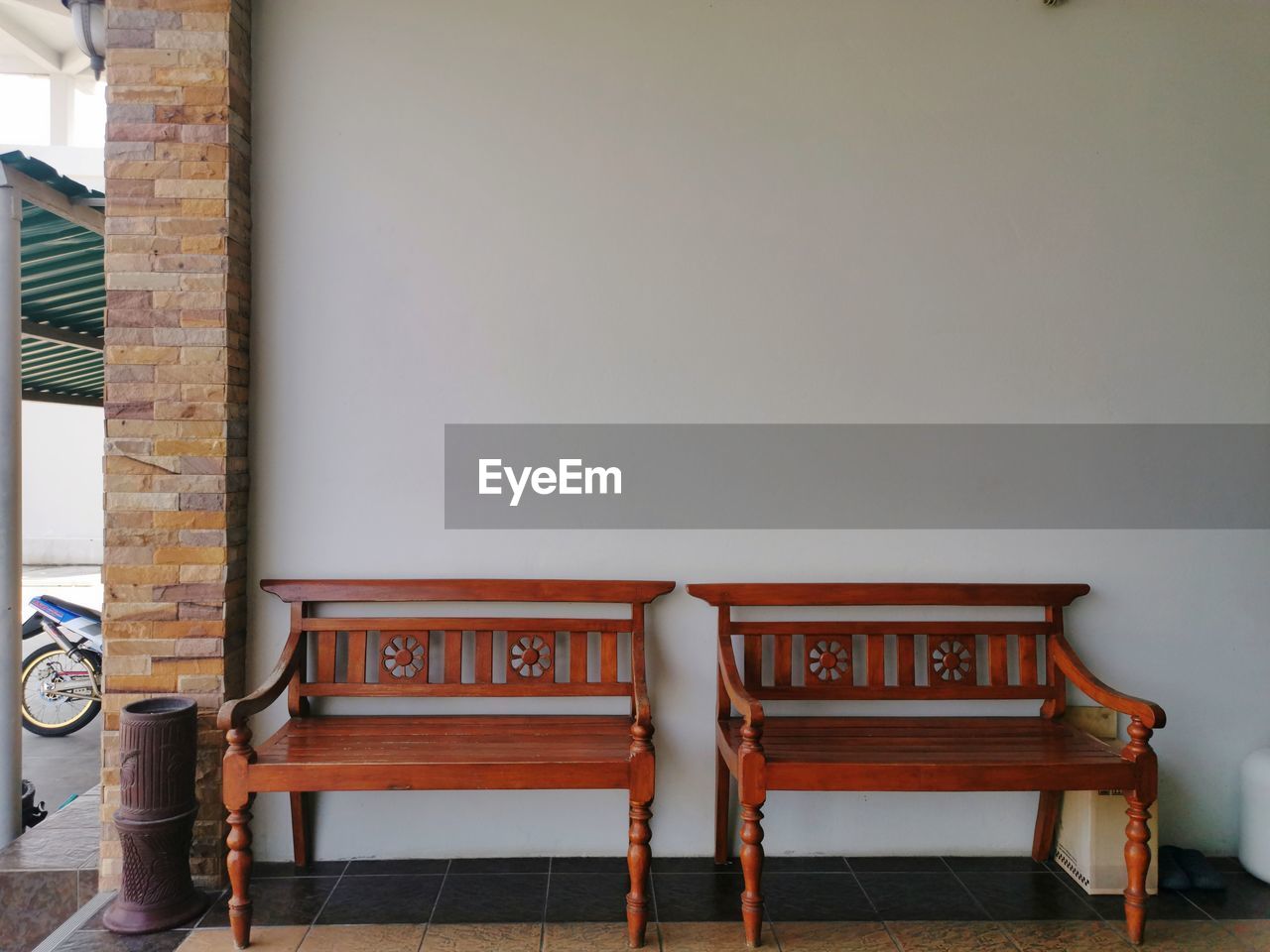 EMPTY CHAIR AGAINST WALL IN BUILDING