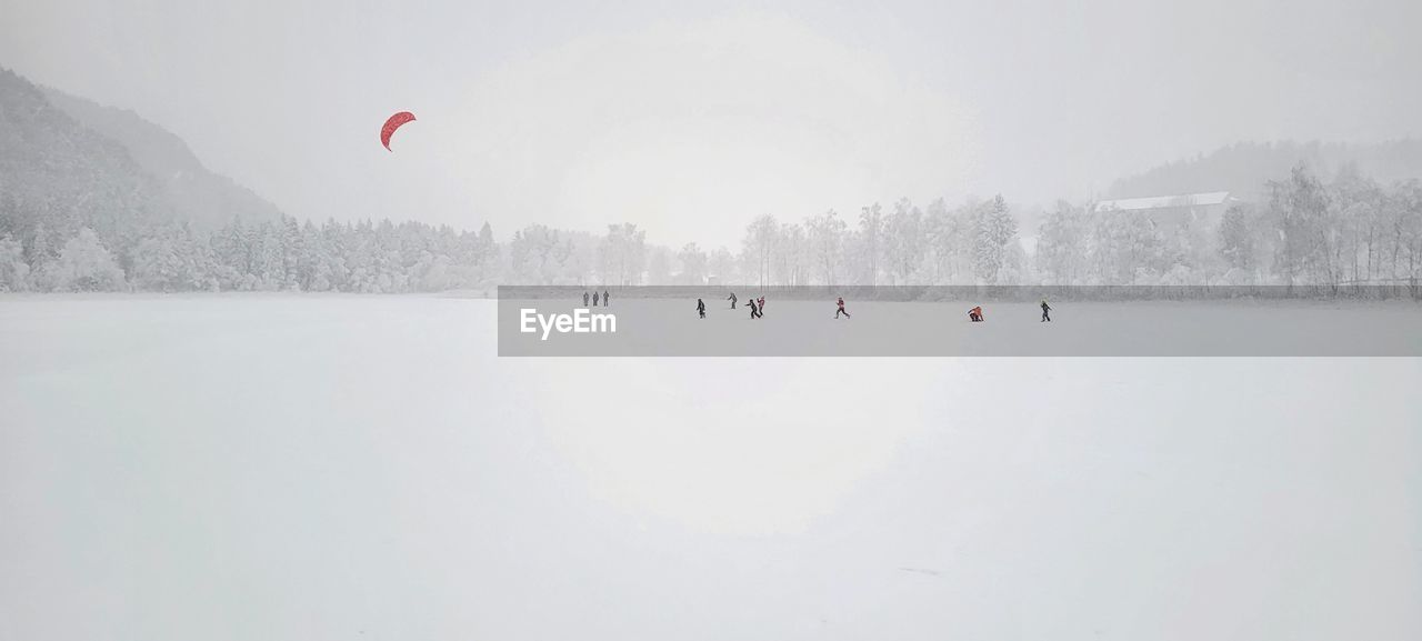 People on snow covered frozen lake