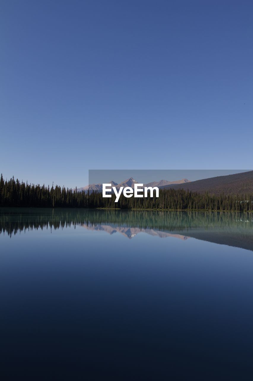 Calm lake against clear sky