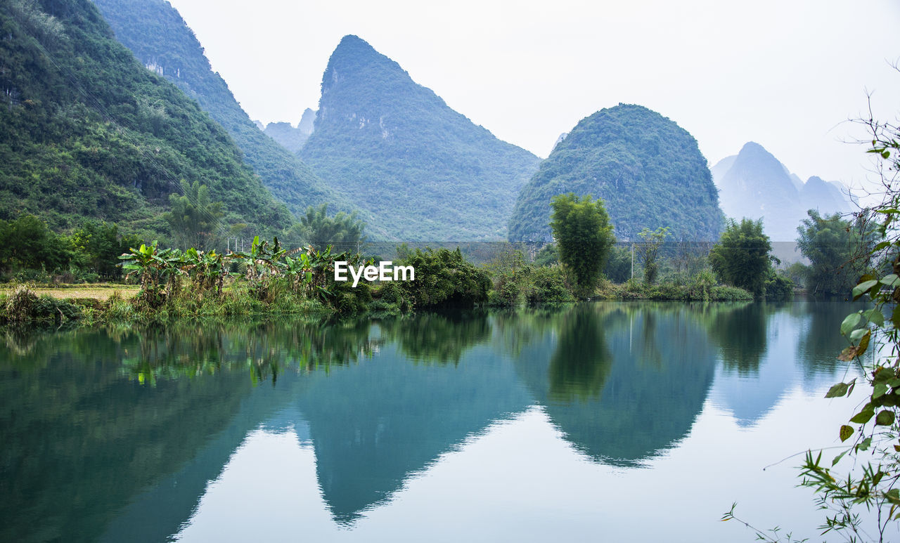 Scenic view of lake and mountains against clear sky