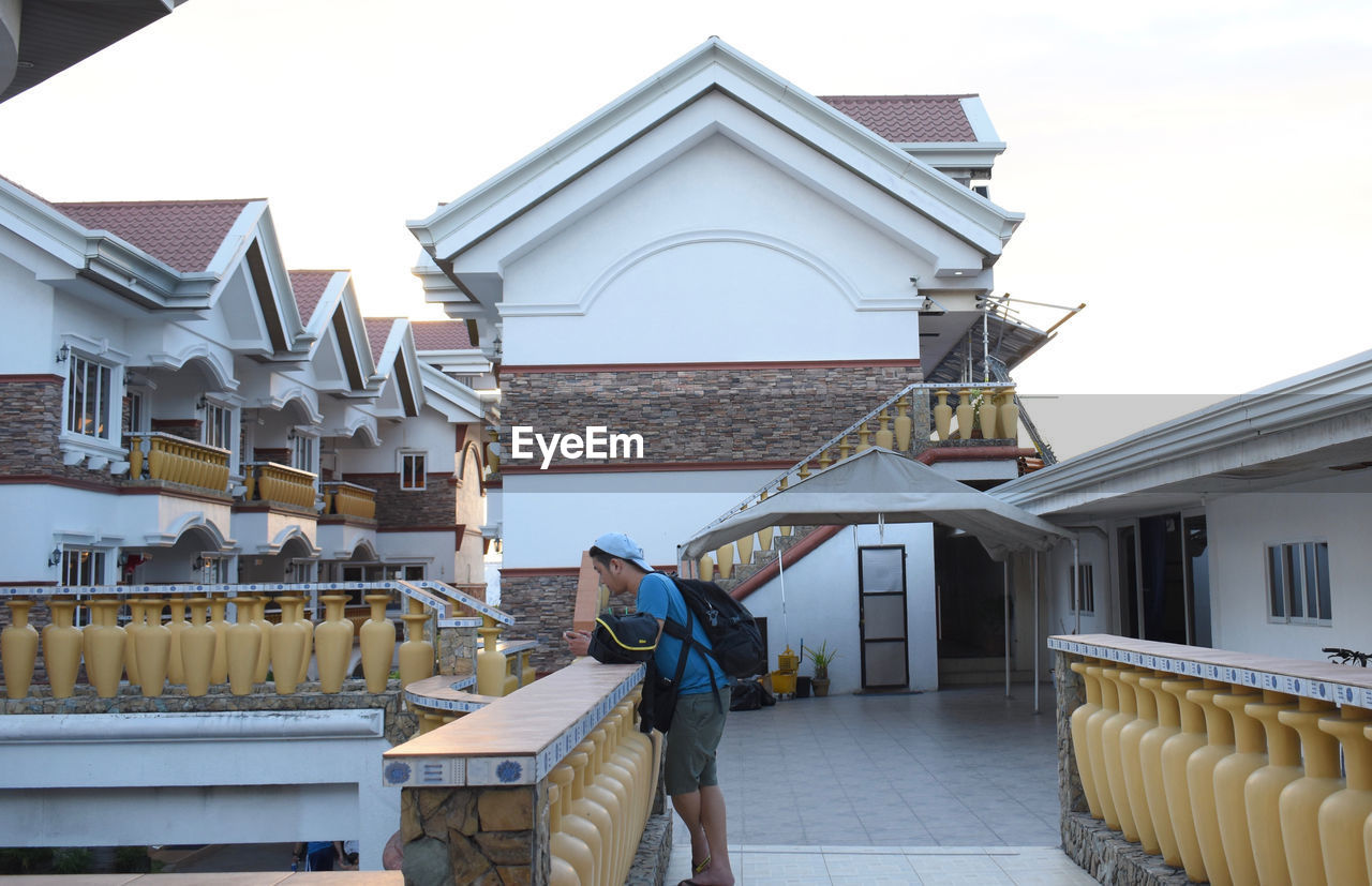 MAN IN FRONT OF BUILT STRUCTURES