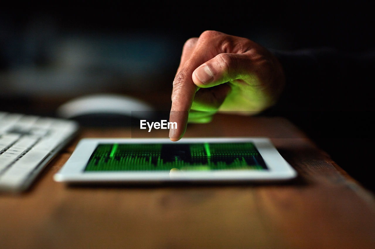 cropped hand of woman using laptop on table