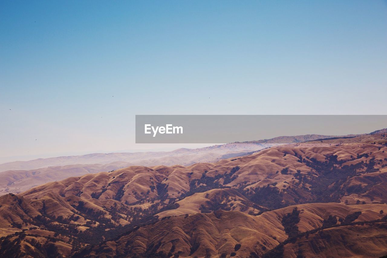 High angle view of mountains against clear blue sky