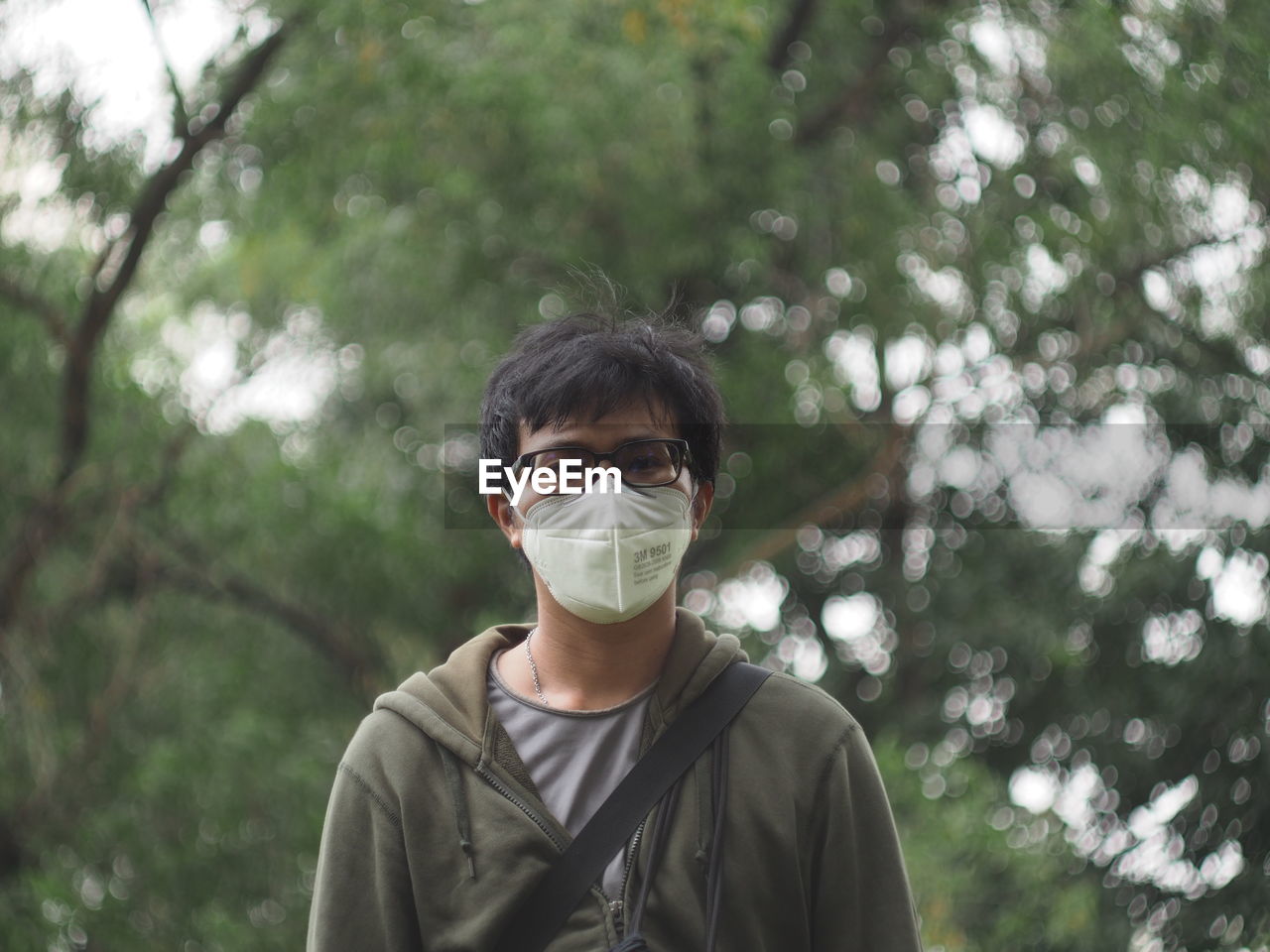 Portrait of man wearing mask while standing against trees