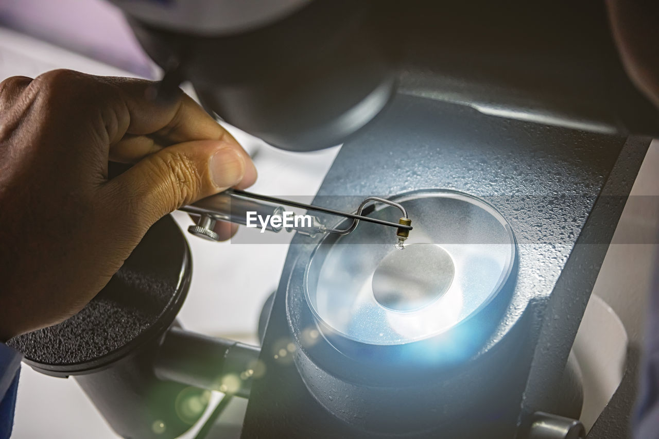 HIGH ANGLE VIEW OF MAN WORKING AT MACHINE