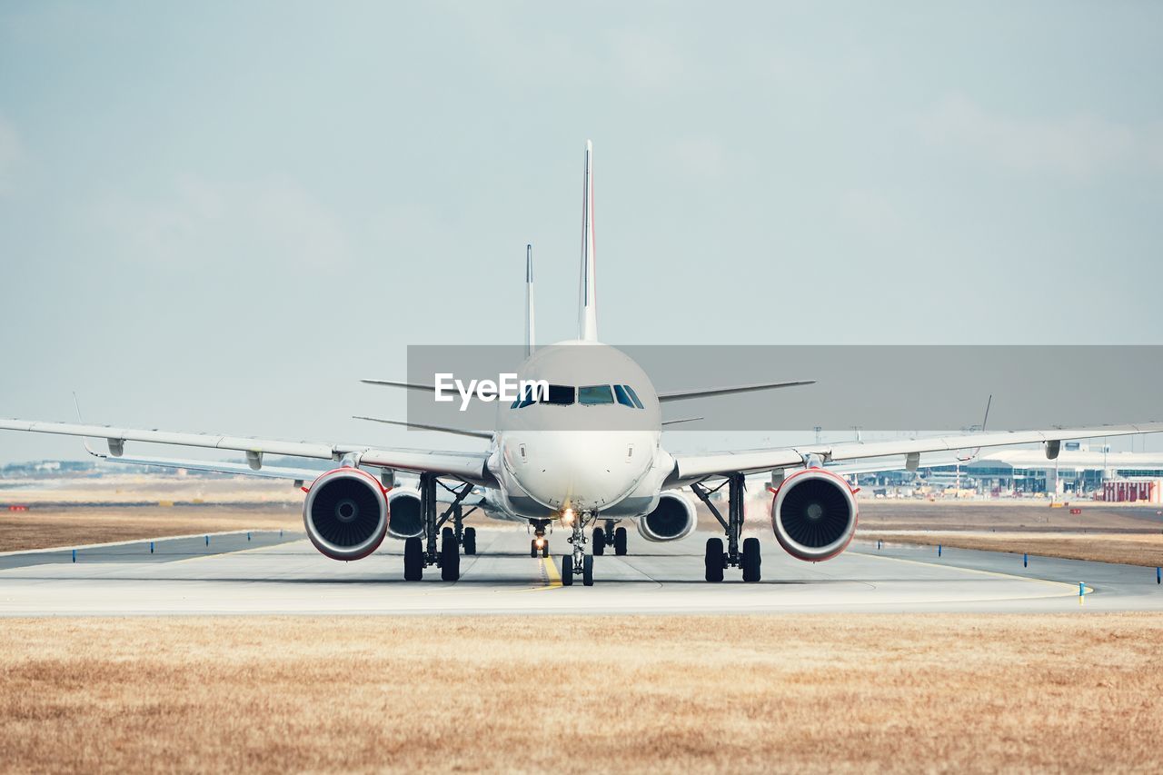 Airplane on runway against sky