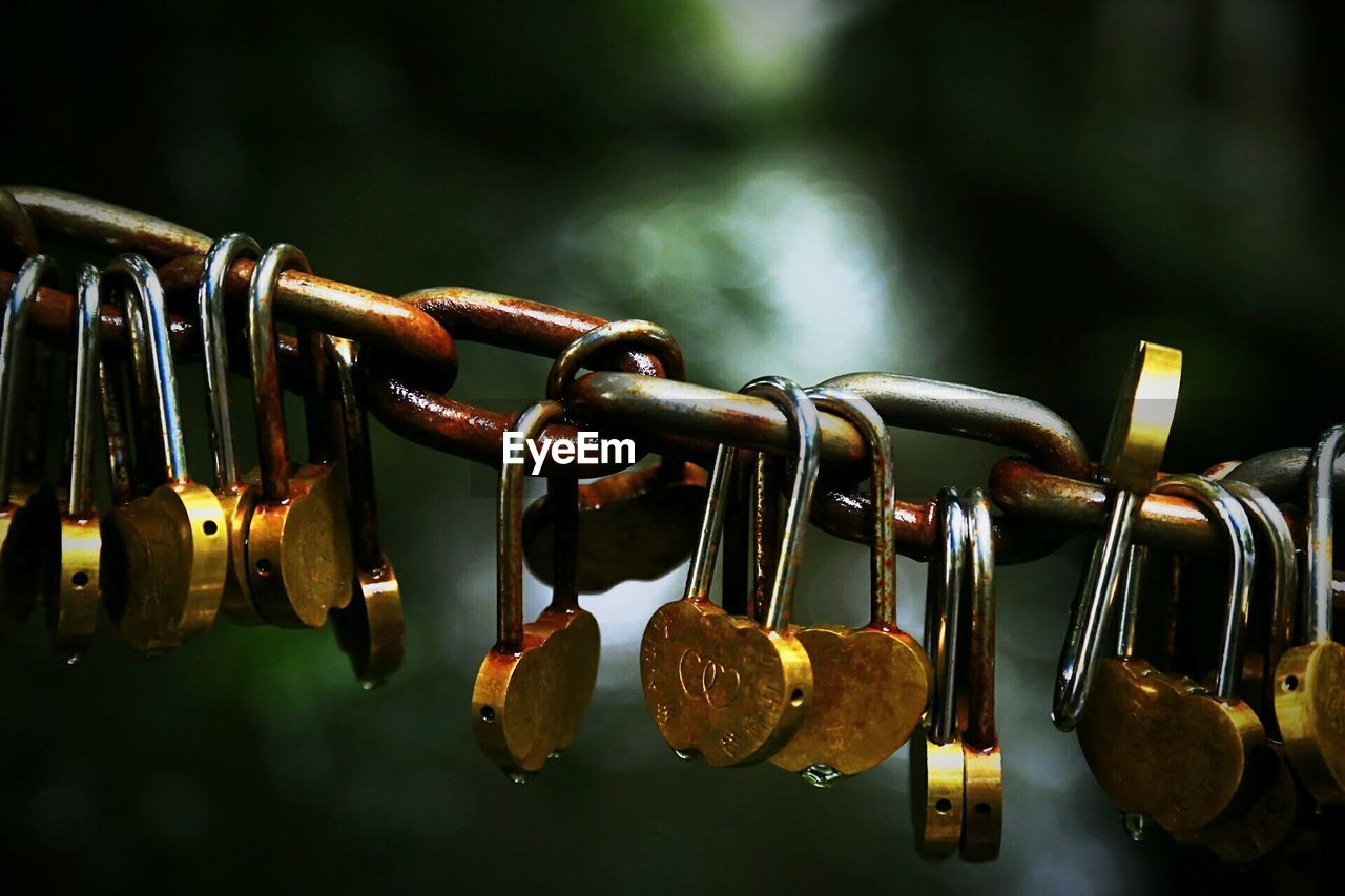 Close-up of love locks hanging to chain