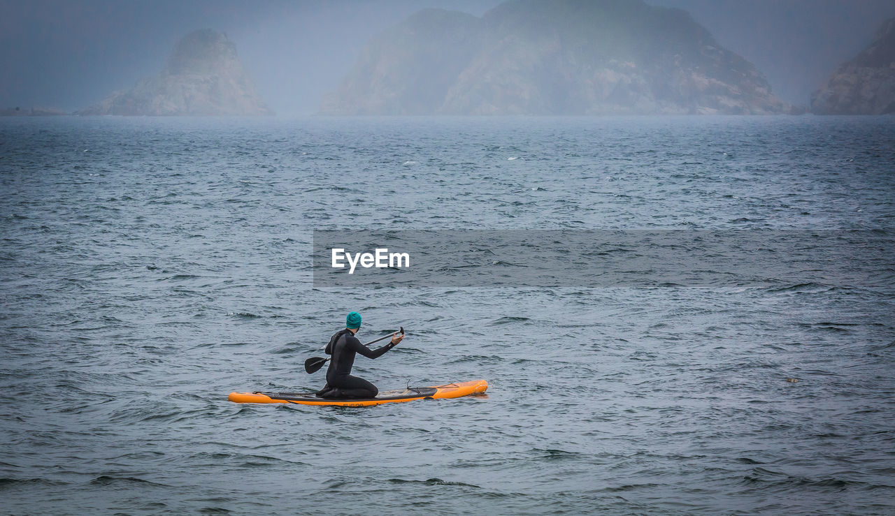 Man paddleboarding in sea