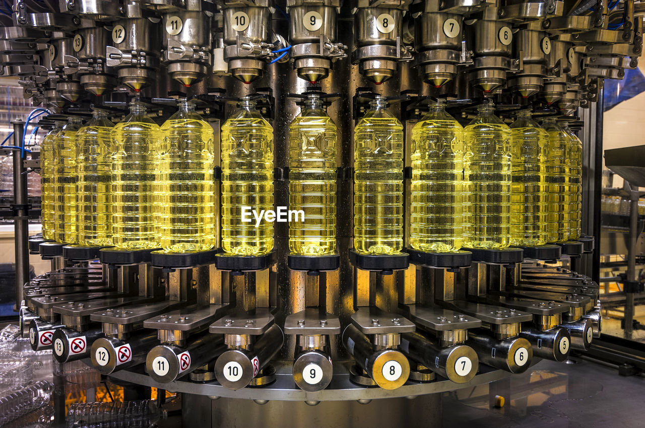 Close-up of machinery with bottles in factory