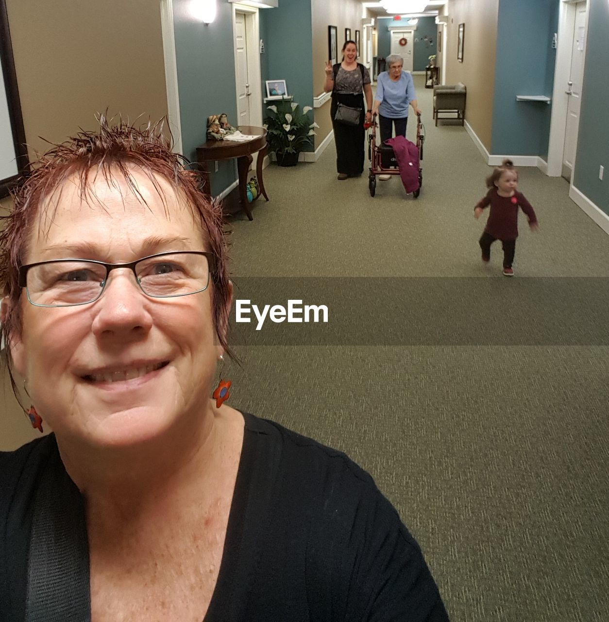 PORTRAIT OF A SMILING WOMAN IN CORRIDOR