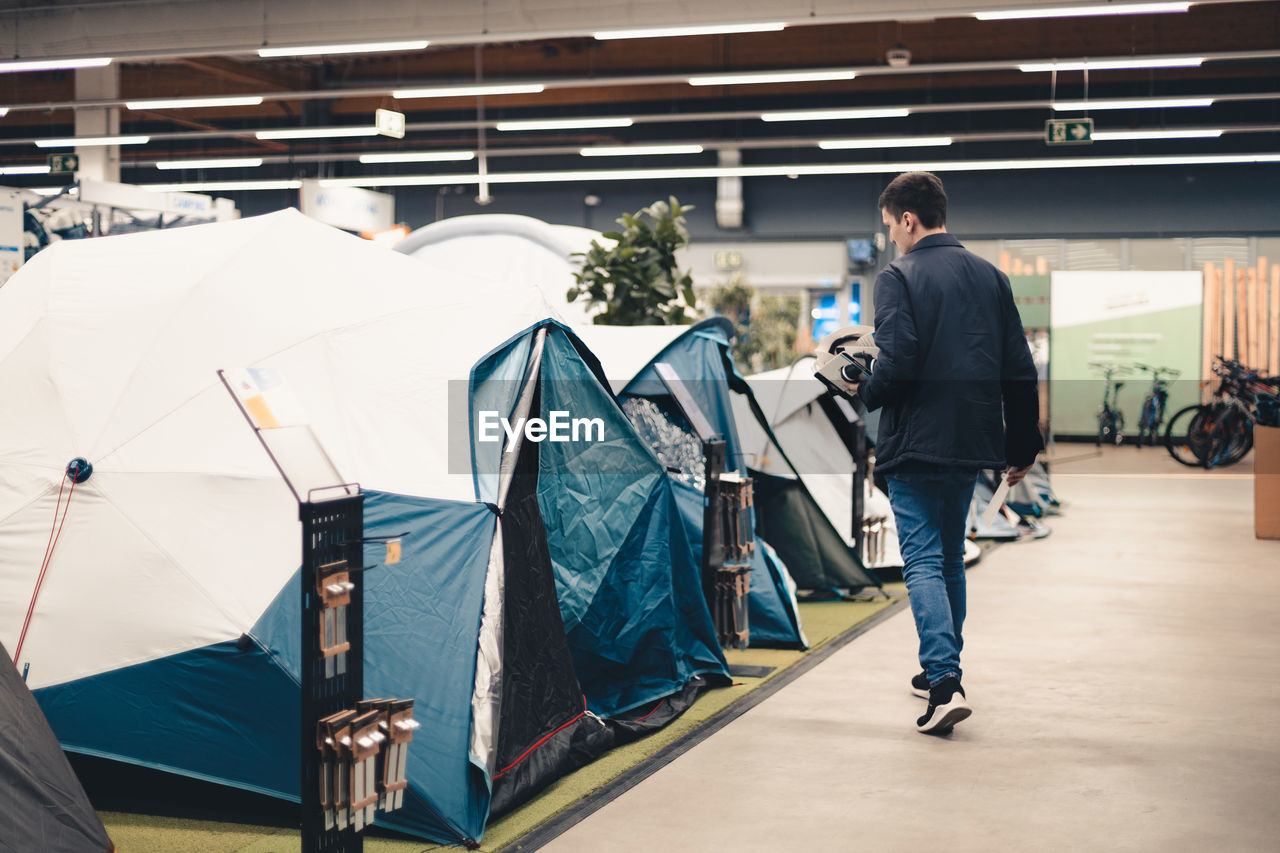 A young man examines the tents in the store.