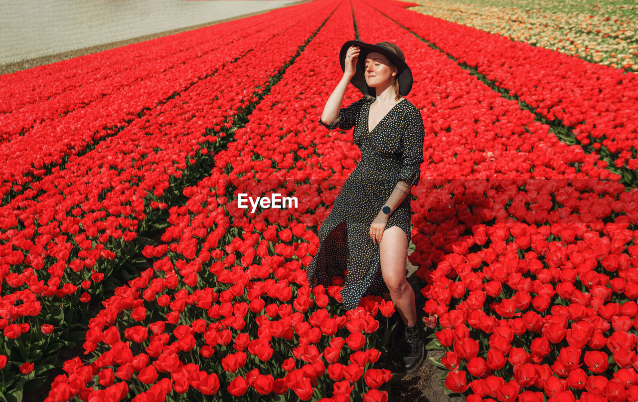 Woman on red flowering plant