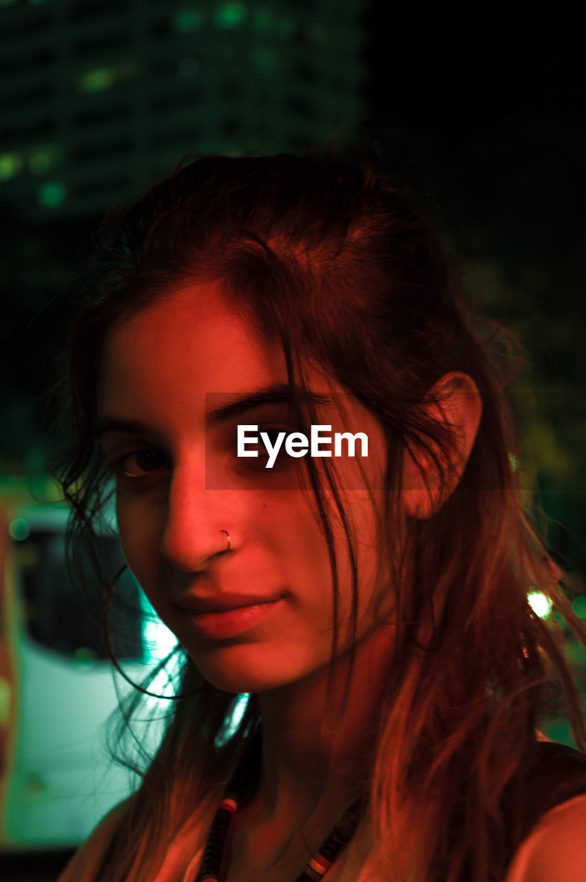 Close-up portrait of young woman at night