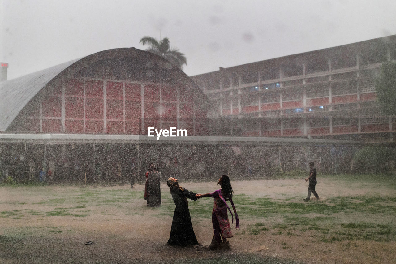 People enjoying rain on field