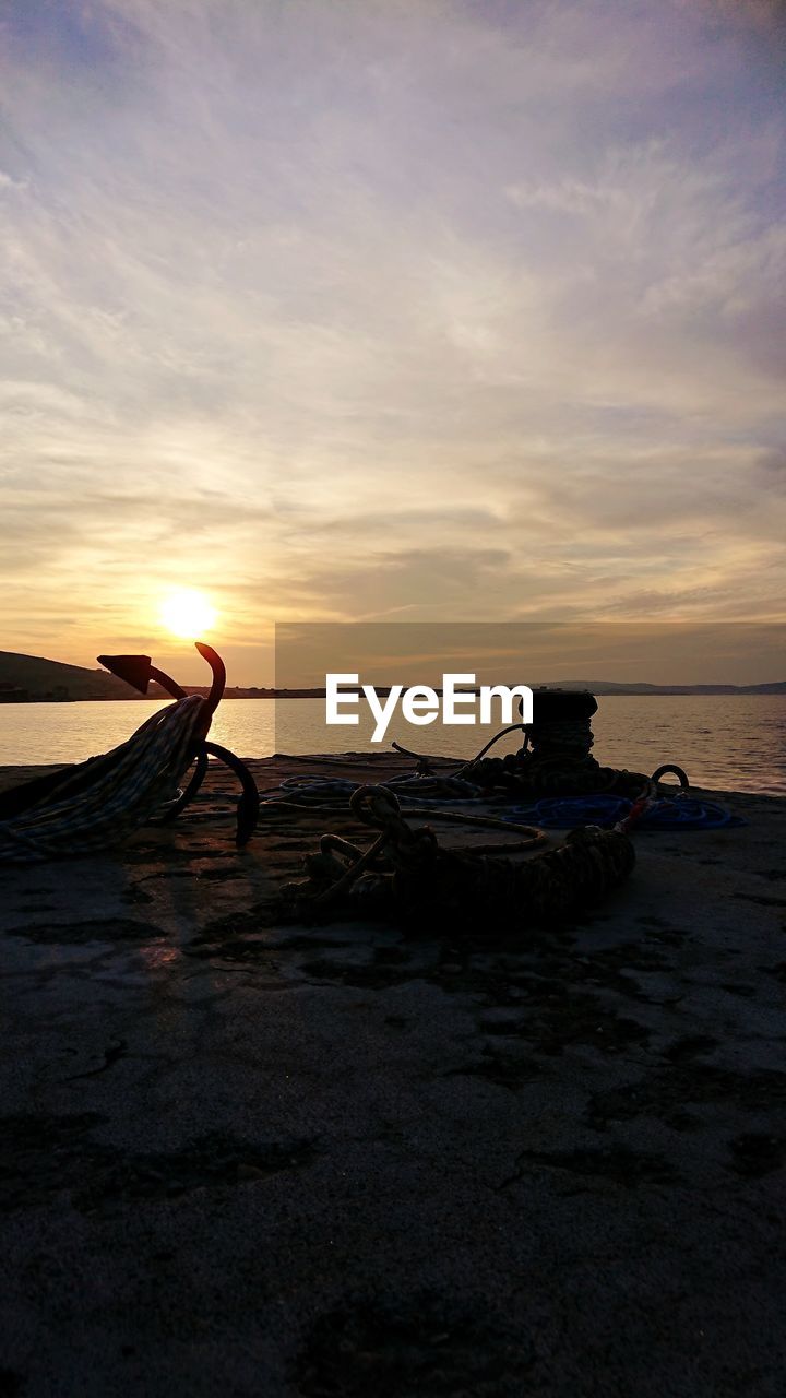 BOAT ON BEACH AGAINST SKY DURING SUNSET