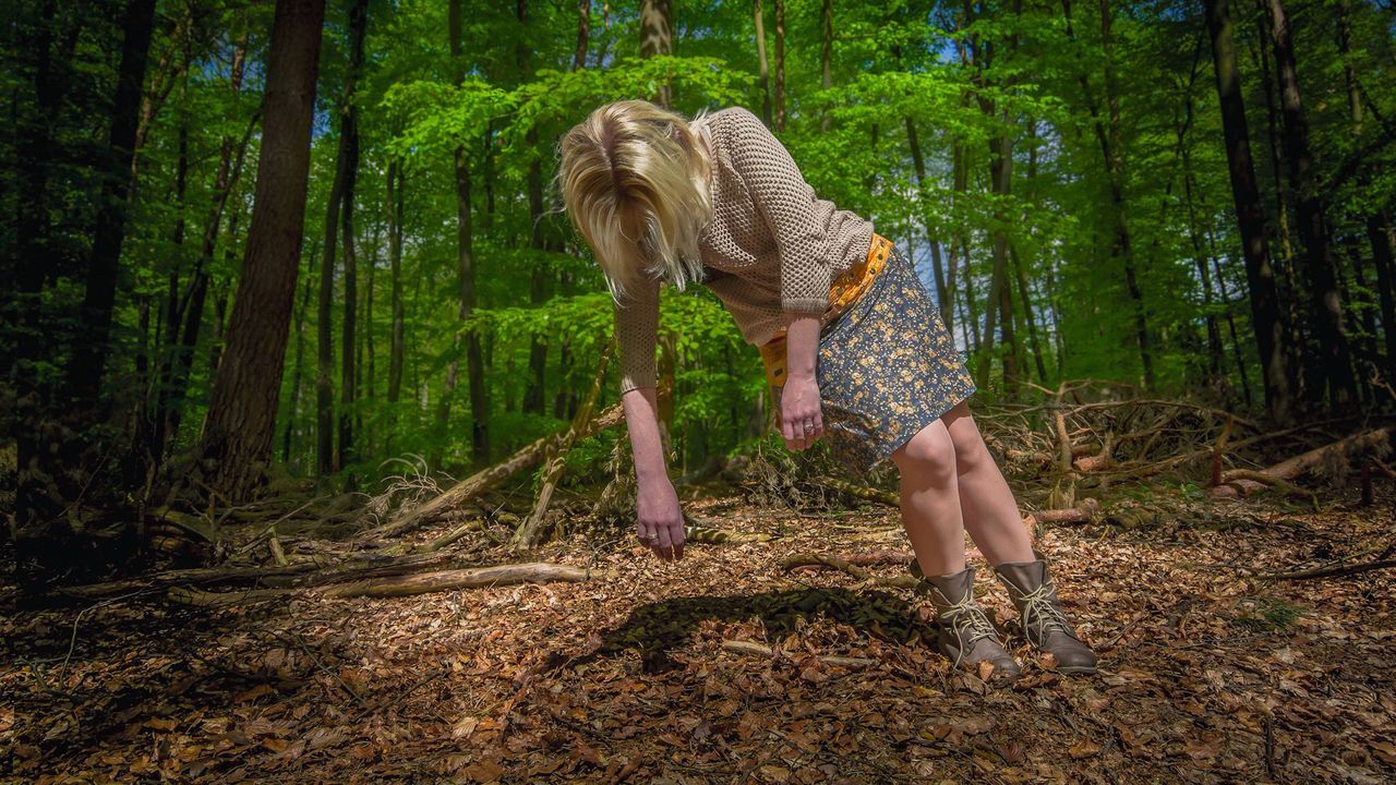 Full length of woman levitates in forest