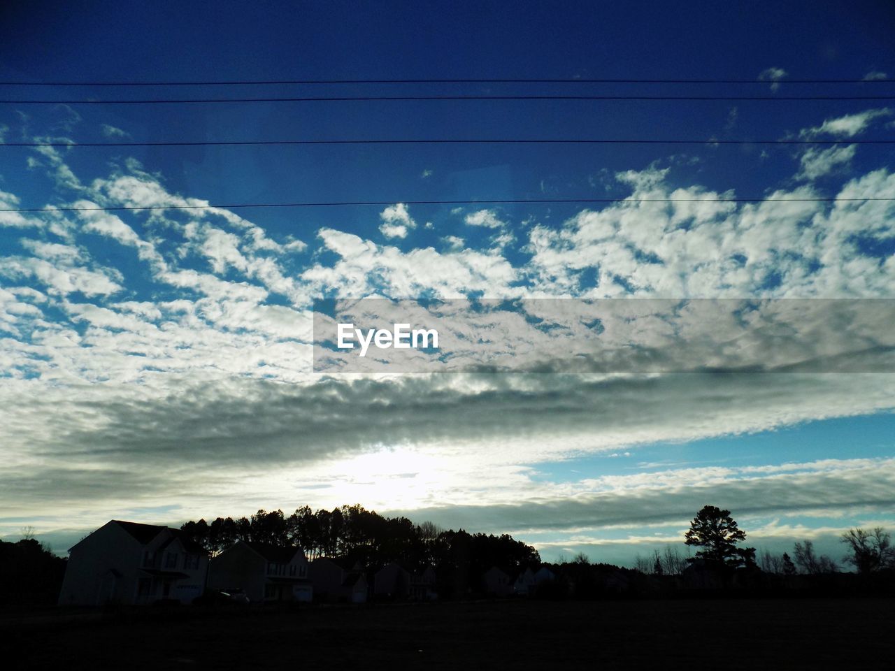 SILHOUETTE HOUSES AGAINST SKY AT SUNSET