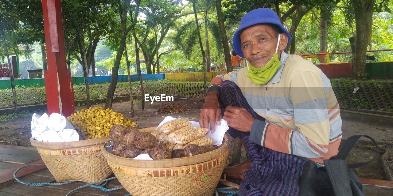 Full length of man standing by basket