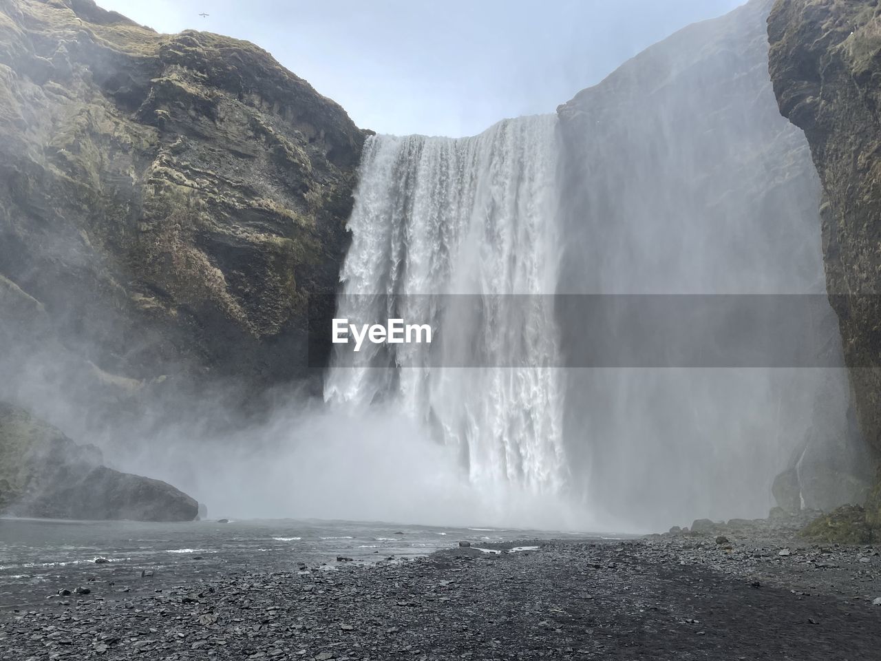 scenic view of waterfall against mountain