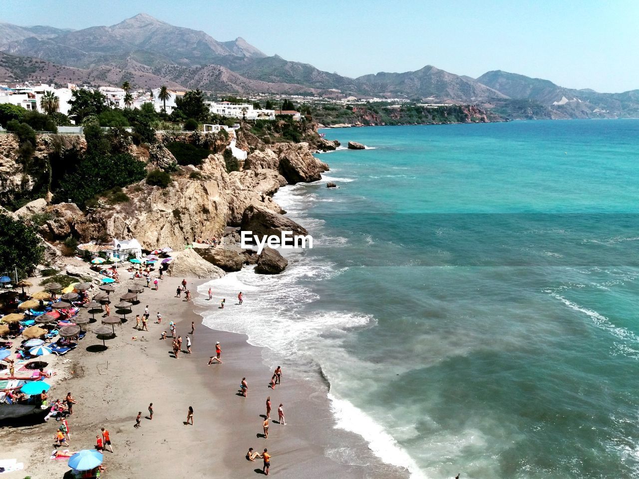 HIGH ANGLE VIEW OF PEOPLE ON SEA SHORE