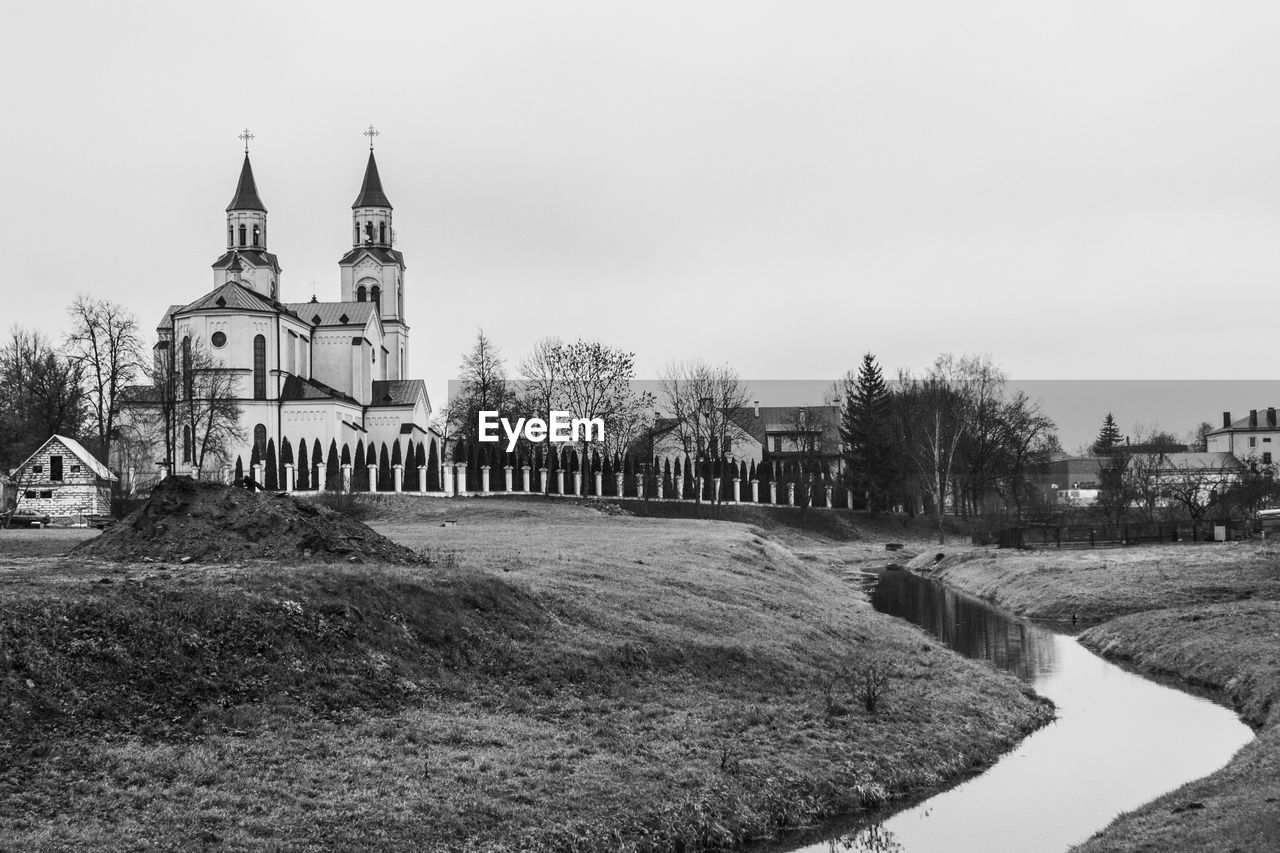 Church by field against clear sky