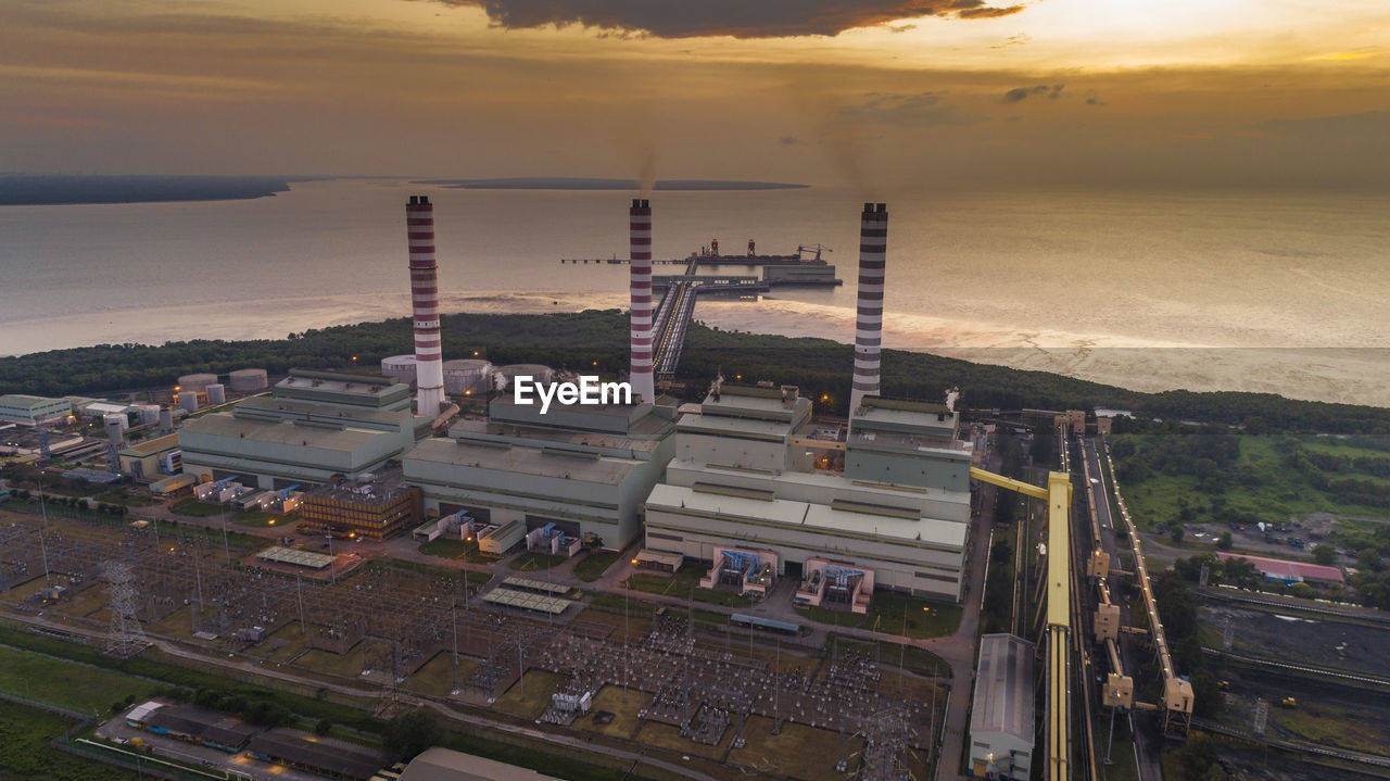 HIGH ANGLE VIEW OF INDUSTRY AT SUNSET