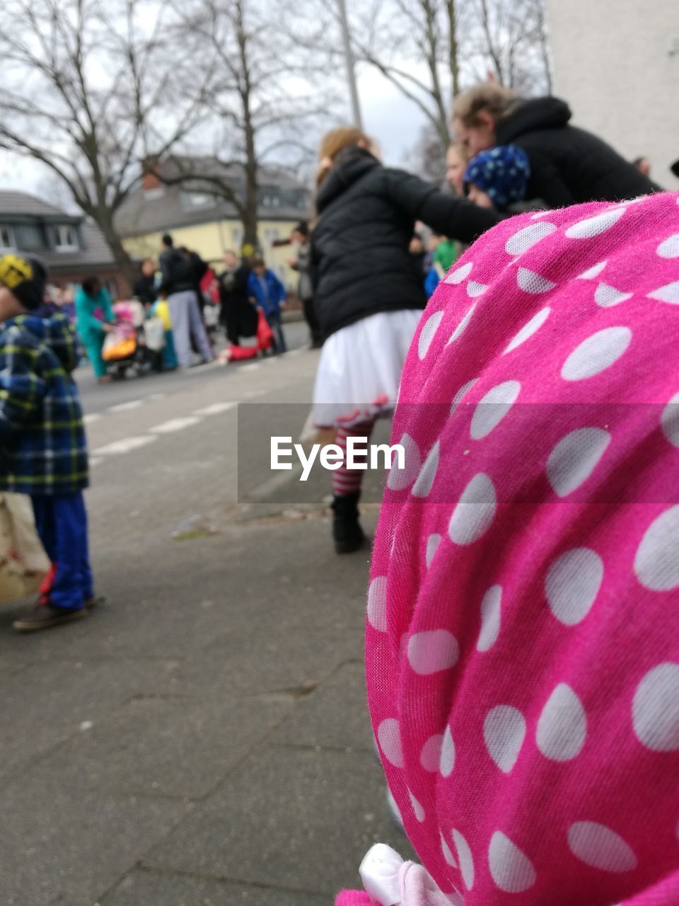 REAR VIEW OF PEOPLE WALKING WITH PINK UMBRELLA