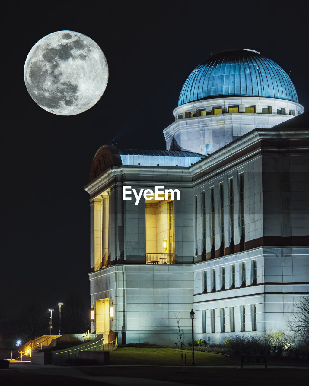 LOW ANGLE VIEW OF ILLUMINATED BUILDING AT NIGHT