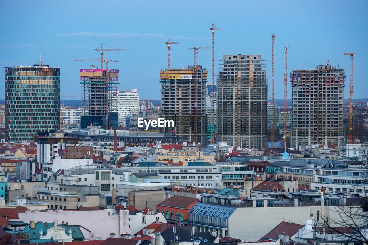 HIGH ANGLE VIEW OF MODERN BUILDINGS IN CITY AGAINST SKY