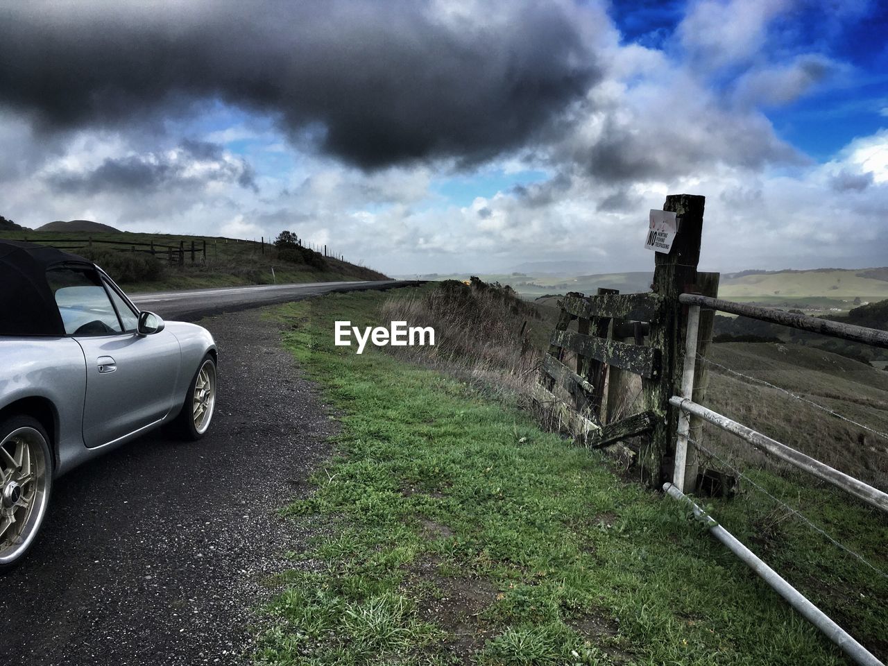 Car on road by land against sky