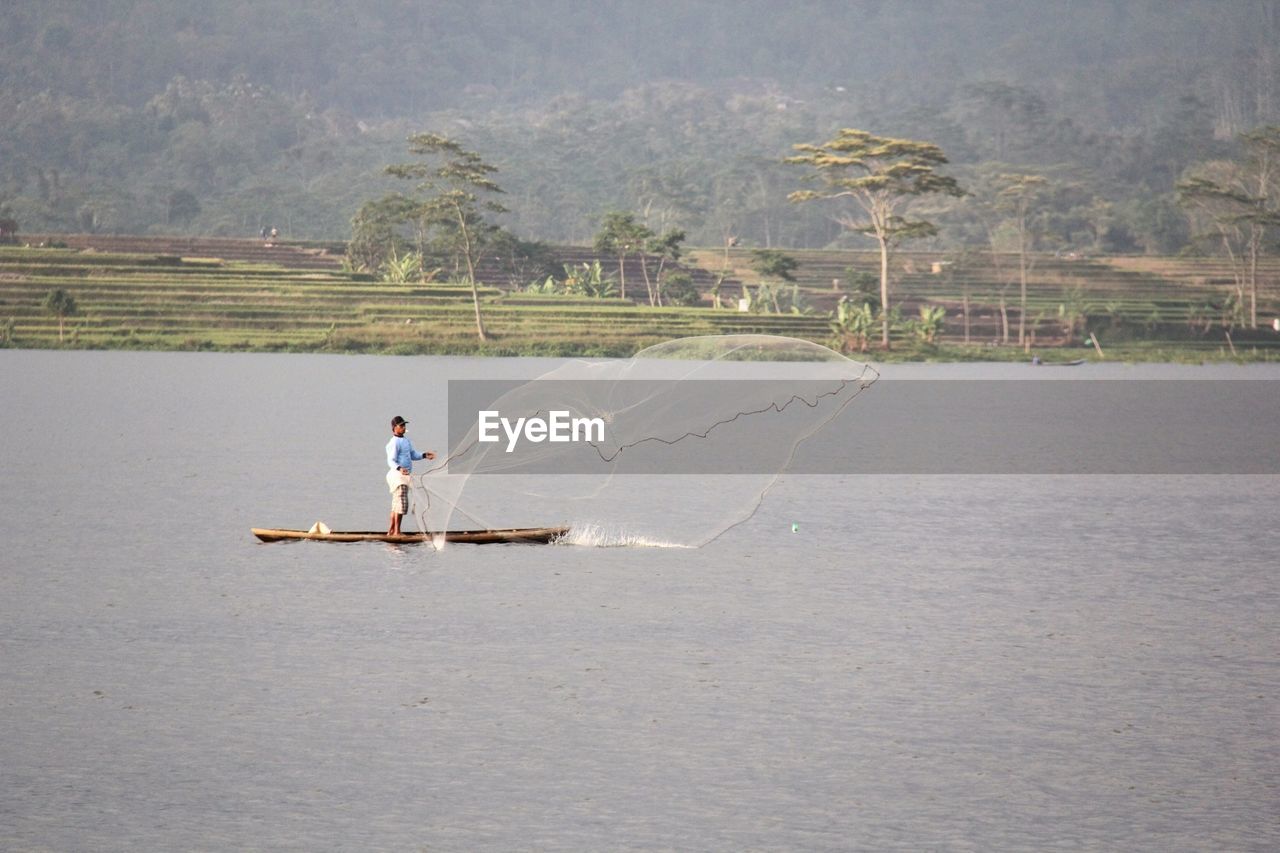 MAN IN BOAT ON WATER