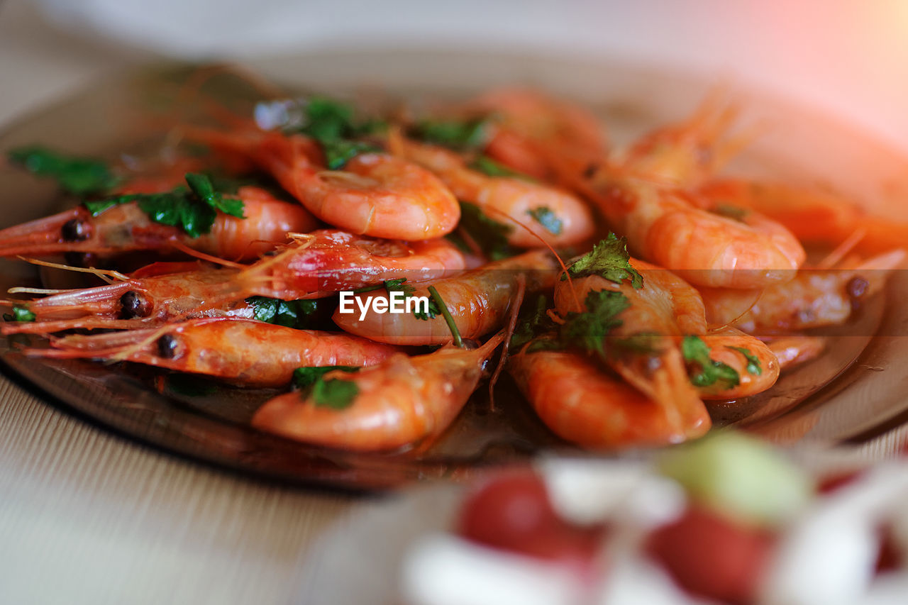 Delicious prawns with coriander in a plate on the table. fresh seafood dish close-up.