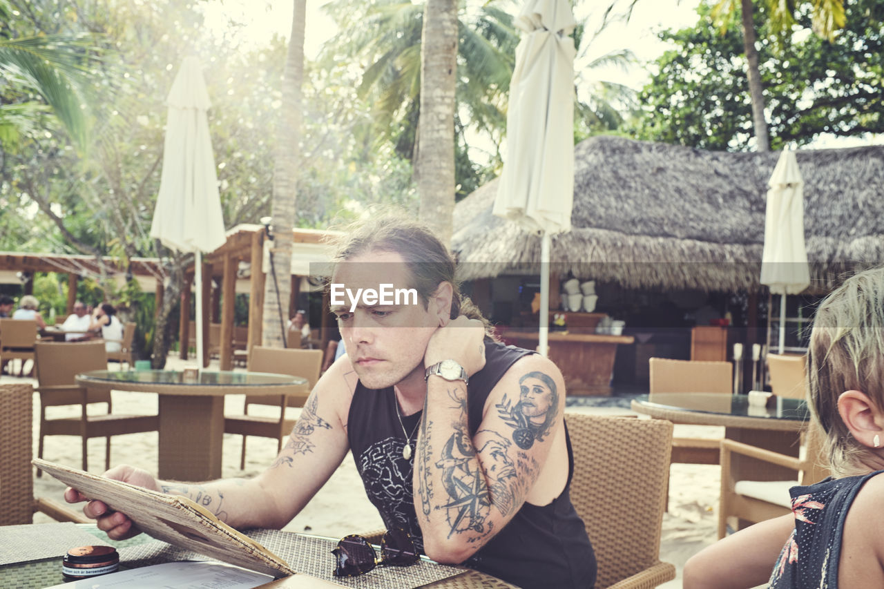 Man reading menu in outdoor restaurant