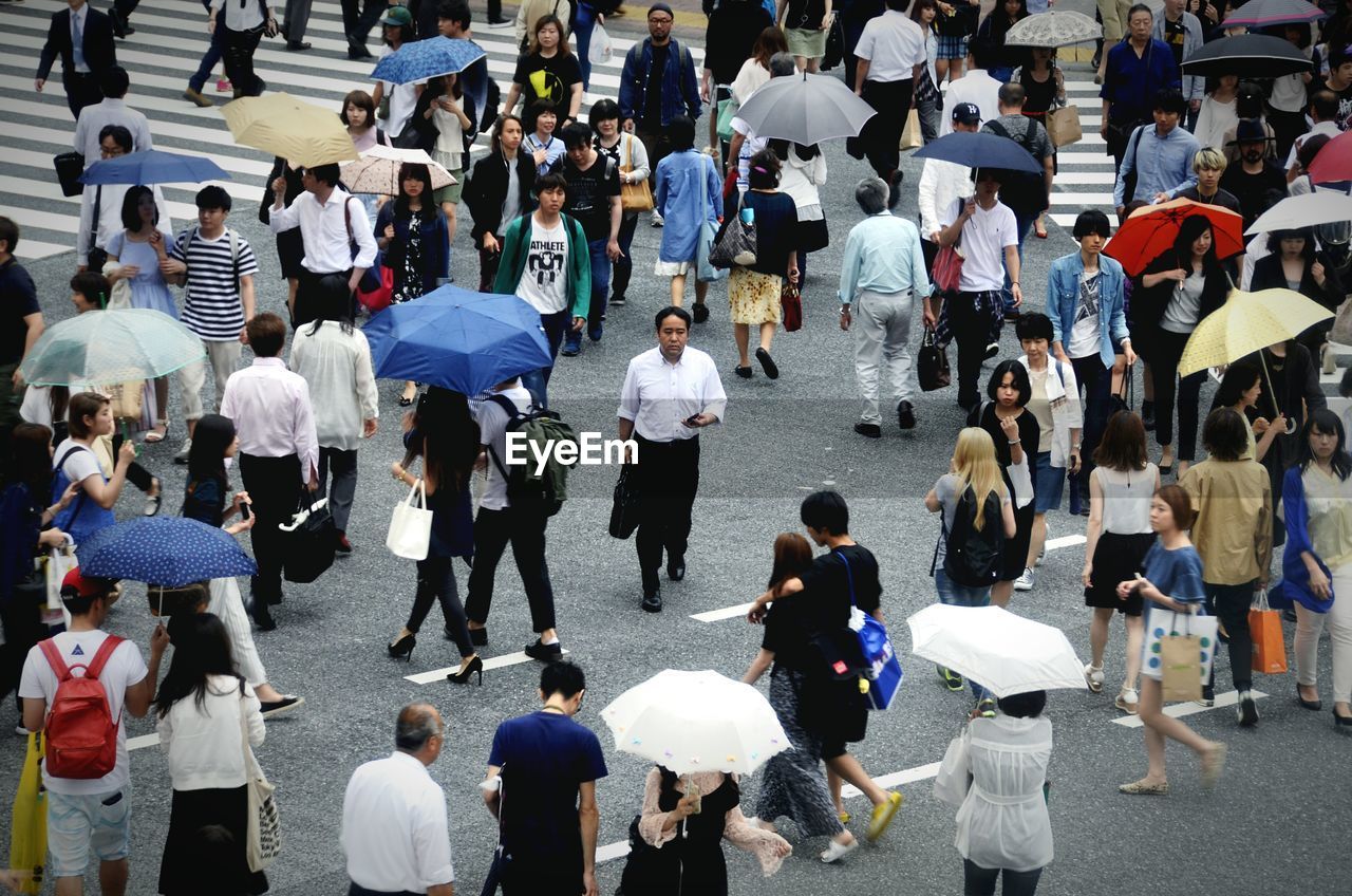 HIGH ANGLE VIEW OF PEOPLE WALKING ON STREET IN CITY