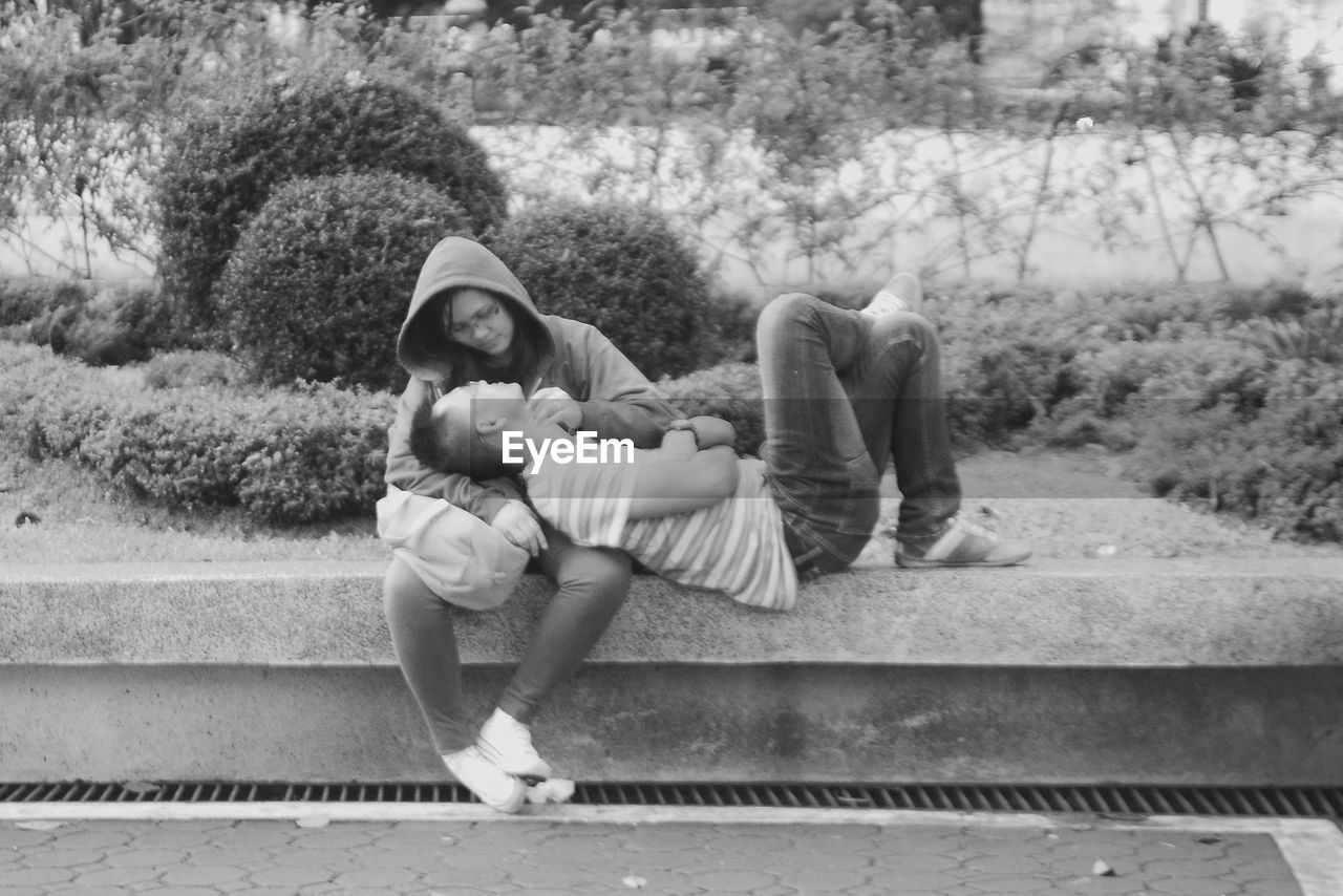 YOUNG COUPLE SITTING ON WALL