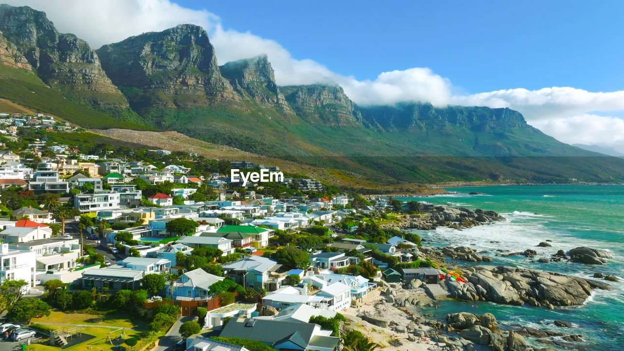 high angle view of townscape by sea against mountain