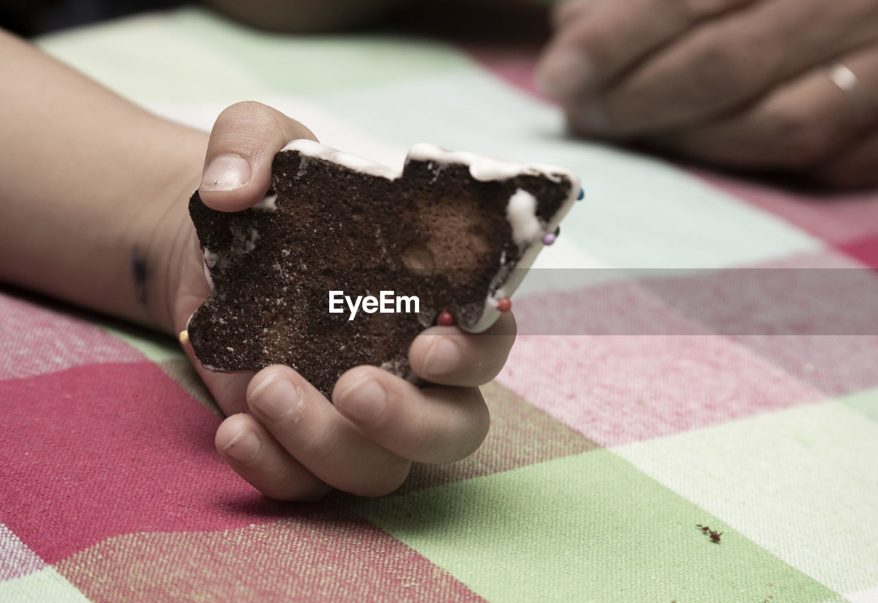 CLOSE-UP OF HAND HOLDING CHOCOLATE ICE CREAM