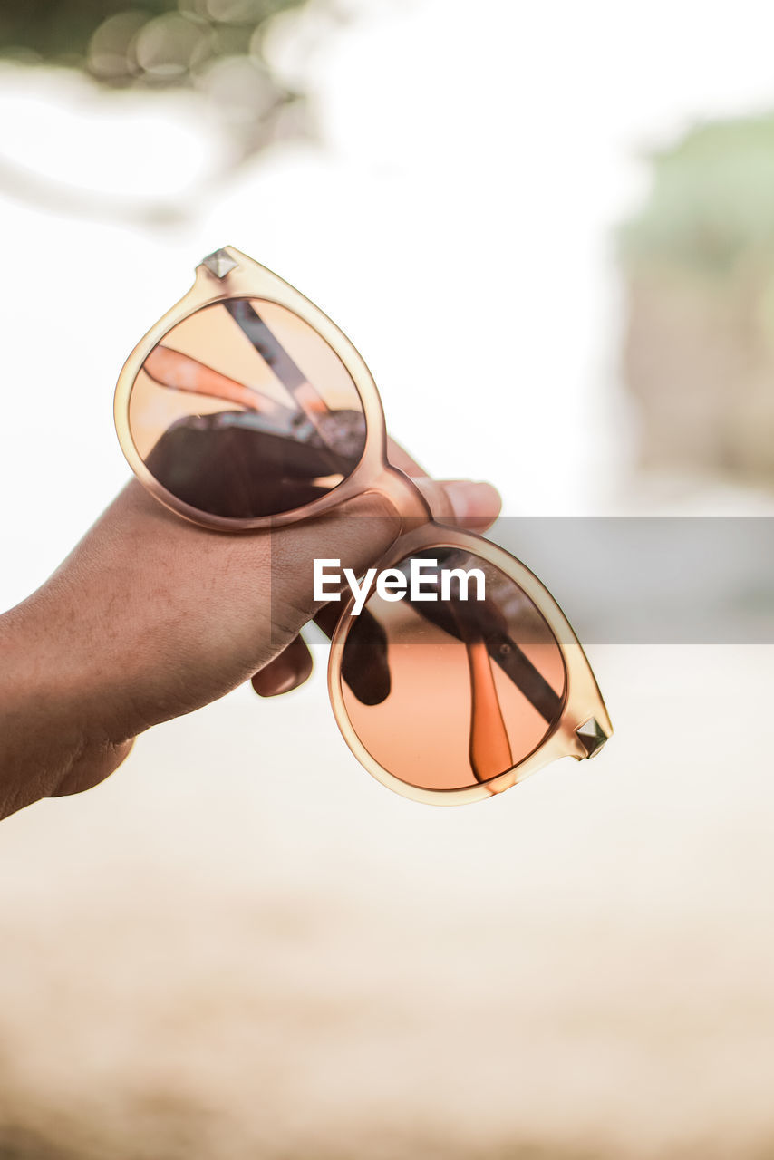 hand, one person, adult, glasses, close-up, sunglasses, holding, fashion, focus on foreground, nature, outdoors, eyewear, brown, fashion accessory, day, lifestyles, leisure activity, vision care, spring, women, summer