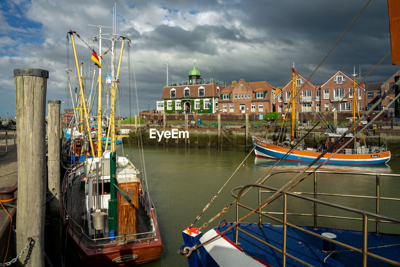 BOATS MOORED AT HARBOR AGAINST SKY