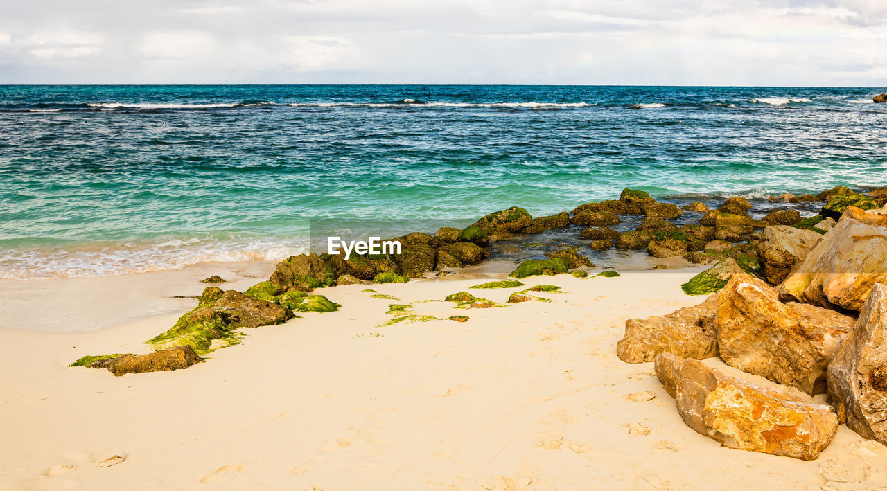 ROCKS ON BEACH AGAINST SKY