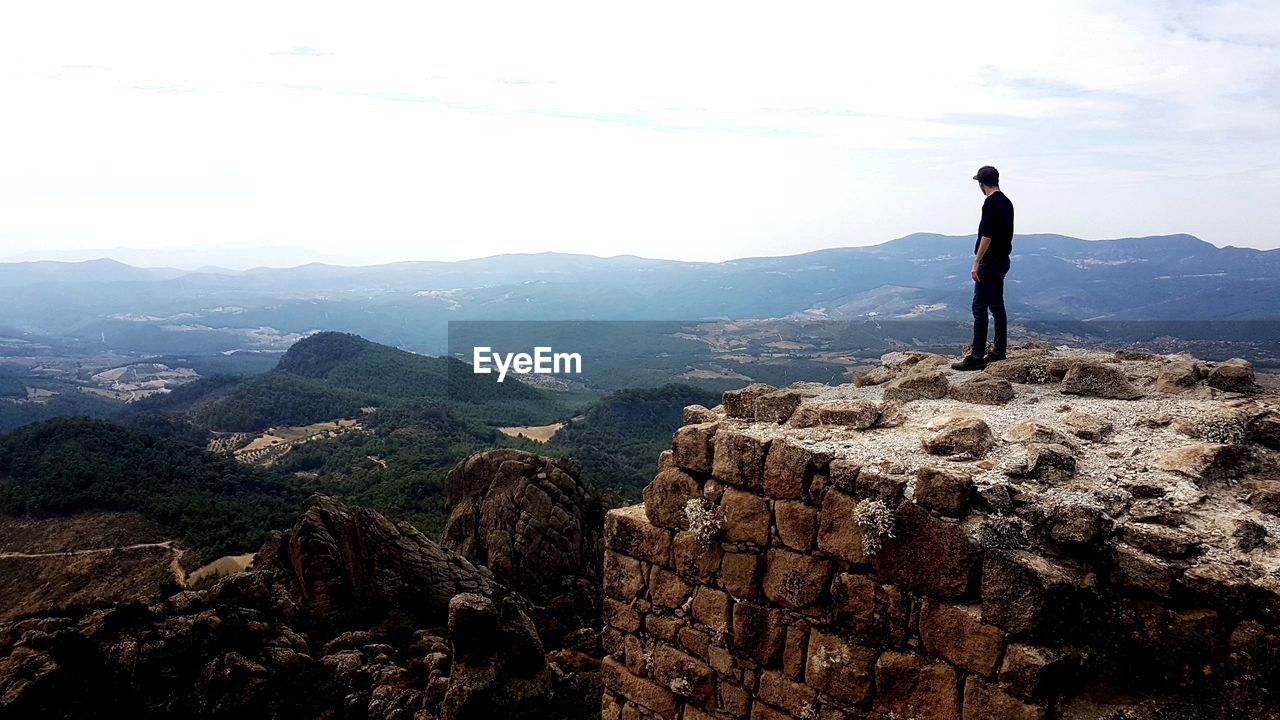 Man standing on mountain against sky