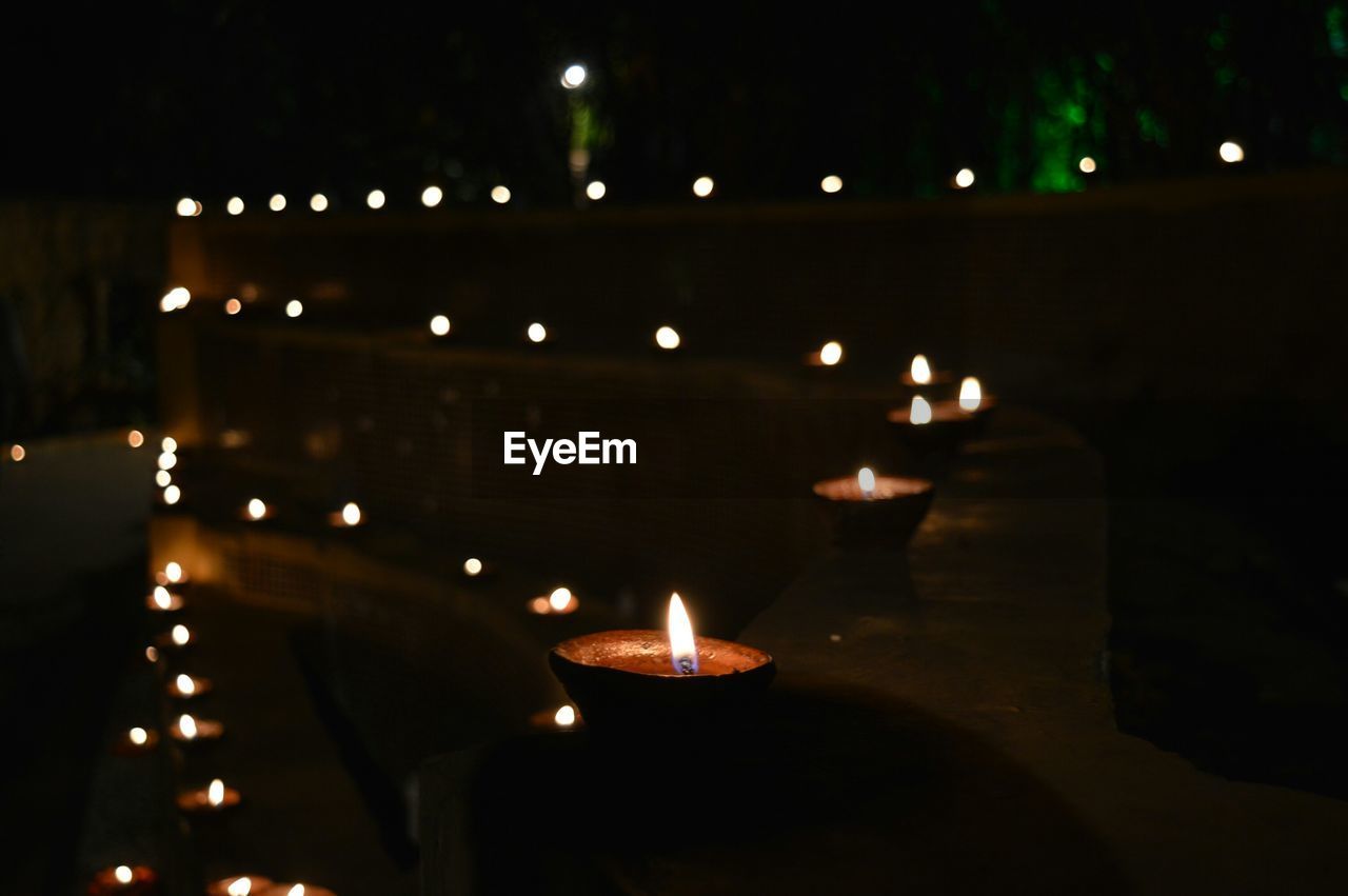 Lit diyas on retaining wall during diwali