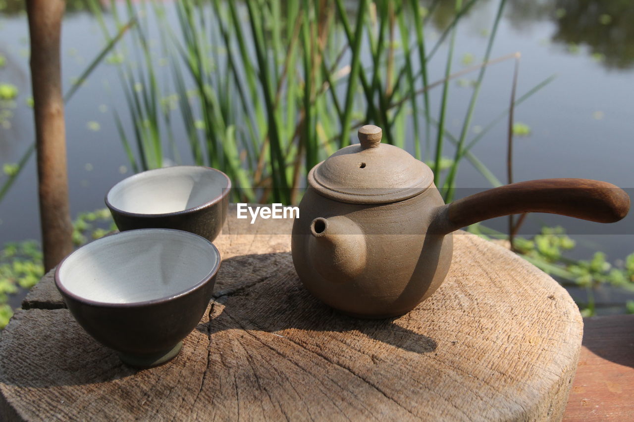 CLOSE-UP OF TEA CUP ON TABLE AGAINST WALL