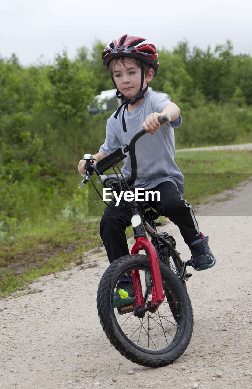 FULL LENGTH OF MAN RIDING BICYCLE ON ROAD