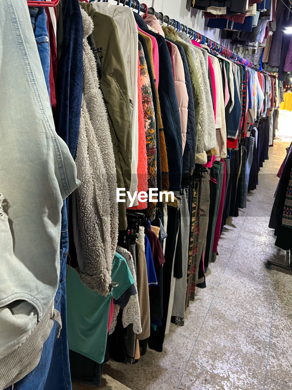 multi colored clothes hanging on rack