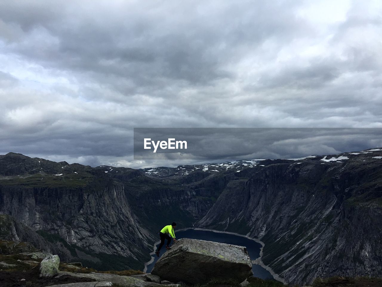 Man standing on rock against sky