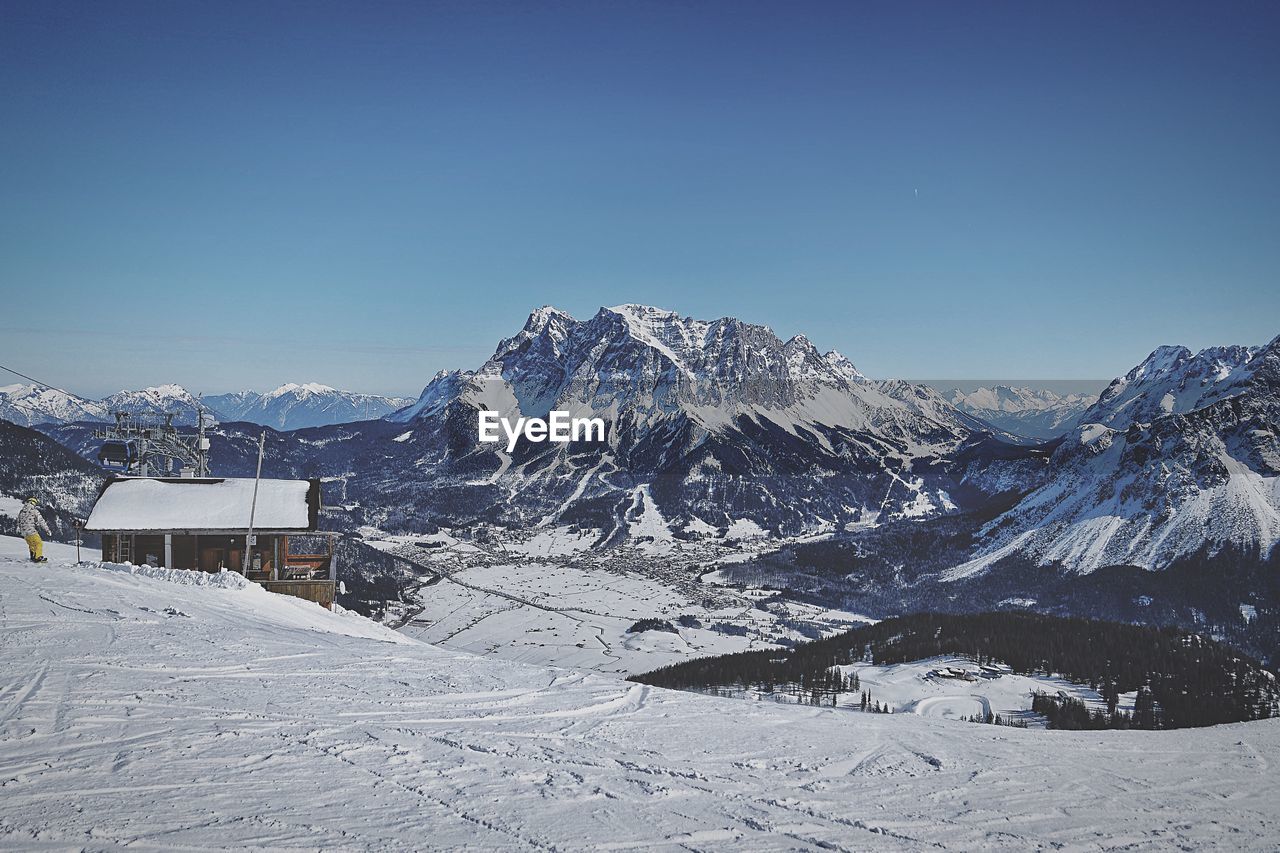 Scenic view of snowcapped mountains against clear blue sky