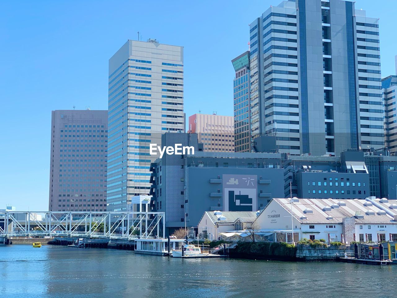 RIVER BY BUILDINGS AGAINST CLEAR SKY