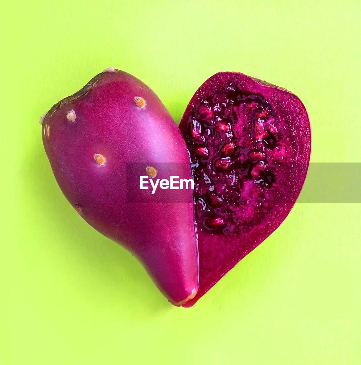 Close-up of purple fruit over green background